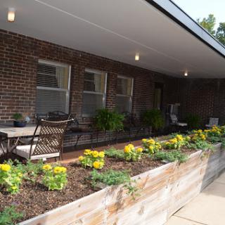 A charming outdoor area featuring a well-maintained garden with vibrant flowers and comfortable seating.