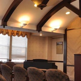 A cozy conference room with upholstered chairs, wood beam ceiling, and ambient lighting.