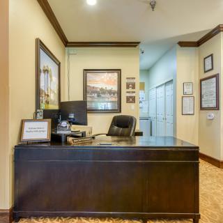 A well-organized office with a desk, chair, computer, and artwork on the walls.