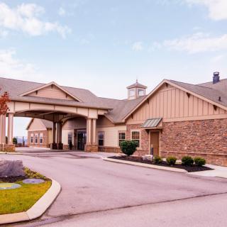 A front view of a large building with an entrance driveway and neat landscaping.