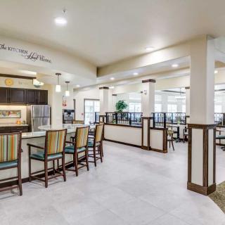 A modern restaurant interior with a bar counter and seating areas.