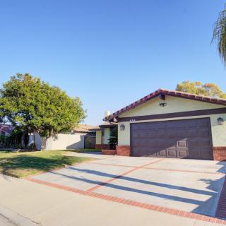 A suburban house with a driveway and garage on a sunny day.