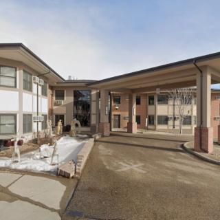 A view of a residential apartment complex with a covered walkway on a clear day.