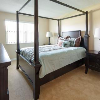 A cozy bedroom featuring a canopy bed, nightstands, and elegant decor.