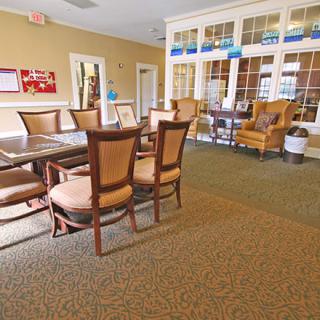 A cozy seating area with a large table and chairs, set in a warmly decorated room.
