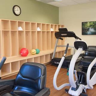 A gym with various exercise equipment and storage shelves.