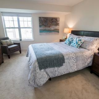 A cozy and well-decorated bedroom featuring a comfortable bed, stylish furniture, and natural light from the windows.