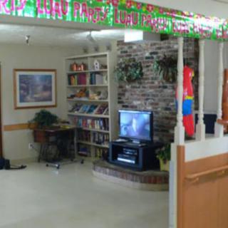 A cozy living room with a television, bookshelf, and decorative elements.