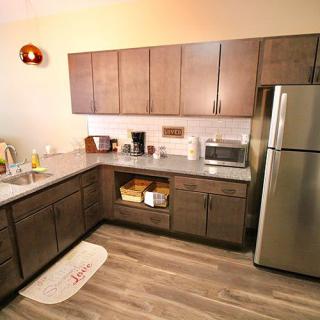 A modern kitchen with wooden cabinets, stainless steel appliances, and a cozy ambiance.