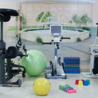 A selection of fitness equipment in a gym, including a stationary bike, exercise balls, and weights.