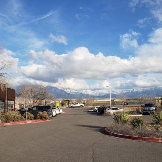 A scenic view of a parking lot with mountains in the background under a cloudy sky.