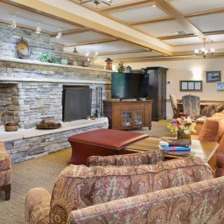 A cozy living room featuring a stone fireplace and comfortable seating.