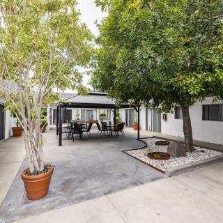 A tranquil outdoor patio area with a gazebo, surrounded by trees and equipped with seating furniture.