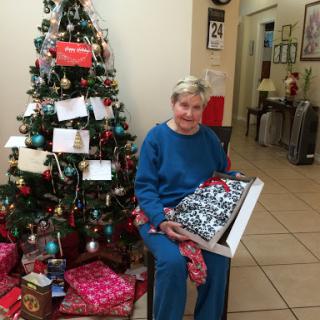 A joyful moment by the Christmas tree, surrounded by festive gifts.