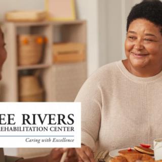 Two people sharing a meal and conversation at Three Rivers Rehabilitation Center.