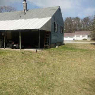 A view of a modest house with a green lawn on a clear day.
