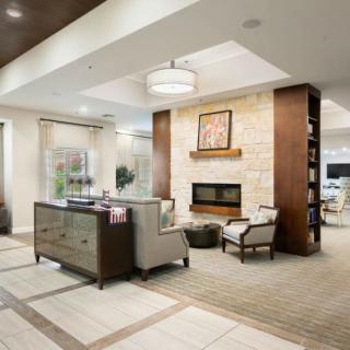 A modern living room with a cozy seating area around a fireplace.