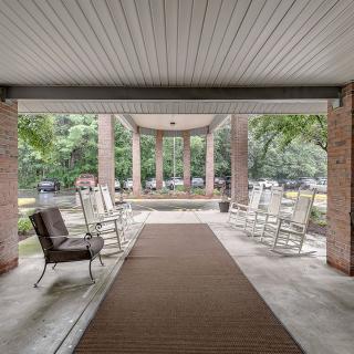 A covered porch area with seating, offering a serene garden view.