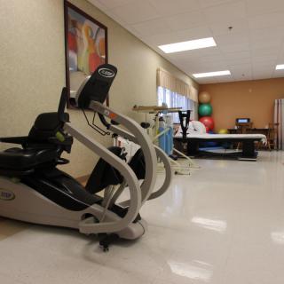 A well-equipped rehabilitation room featuring an exercise bike and other fitness equipment.