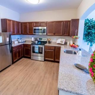 A modern kitchen with wood cabinets and stainless steel appliances.