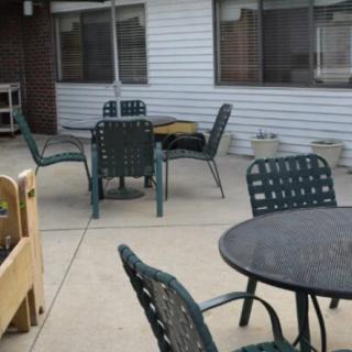 An outdoor patio area with tables and chairs on a concrete surface.