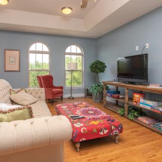 A cozy and inviting living room featuring a comfortable sofa, colorful coffee table, and a television setup.