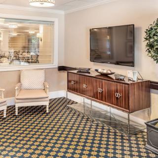 A cozy living room featuring a television, elegant wooden cabinet, and comfortable seating.