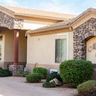 A well-maintained house exterior with stone accents and landscaped bushes.