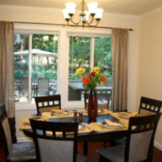 A cozy dining room with a set table and a view of the garden outside.
