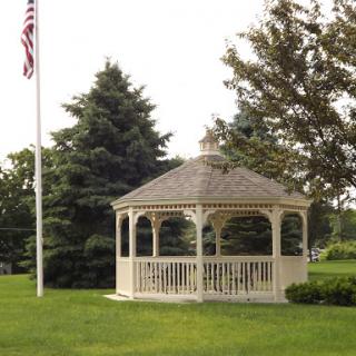 A charming gazebo surrounded by lush greenery and a flag in the background.