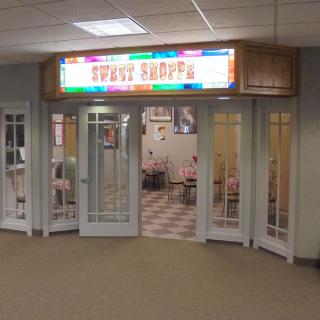 A colorful cafe entrance with glass doors and bright signage.