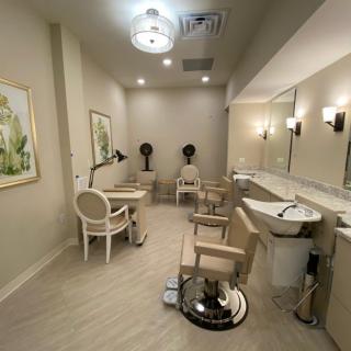 A modern beauty salon interior featuring styling chairs, mirrors, and elegant decor.
