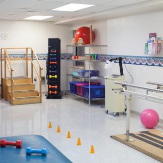 A physical therapy room with various exercise and rehabilitation equipment.