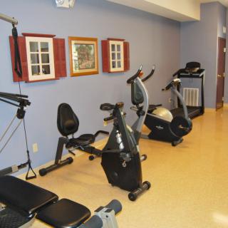 A small gym area with various exercise equipment including stationary bikes.