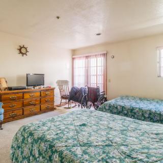 A cozy bedroom with two beds, a television, and nautical decor.