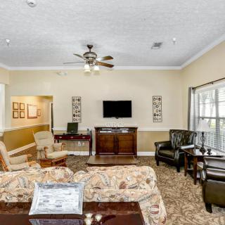 A cozy living room with a television, sofas, and elegant decor.