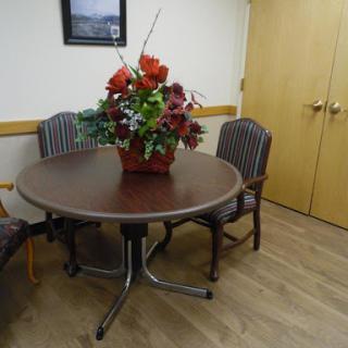 A round table surrounded by chairs, adorned with a vibrant floral arrangement.