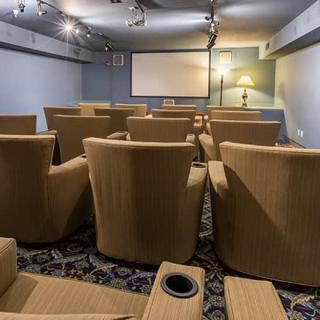 A cozy home theater with comfortable seating facing a projector screen.