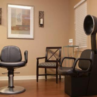 A cozy salon interior featuring chairs and a hair dryer.