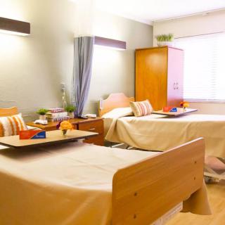 A hospital room with two neatly arranged twin beds.
