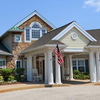 A residential house with a prominent entrance featuring columns and an American flag.