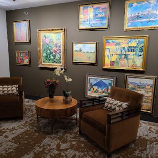A cozy seating area adorned with various paintings, creating a warm and inviting atmosphere.