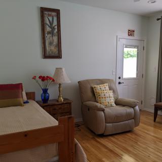A cozy living room with a recliner, bed, and decorative elements.