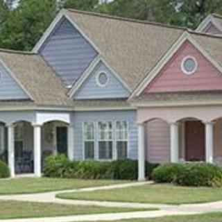 A row of colorful suburban houses with varying shades on their exteriors.