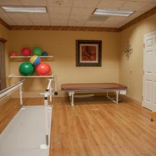A well-equipped therapy room featuring exercise balls and a treatment table, designed for rehabilitation and physical therapy.