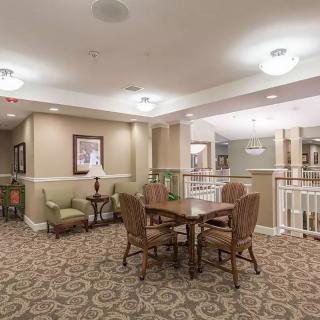 A cozy interior room with a table, chairs, and elegant carpeting.