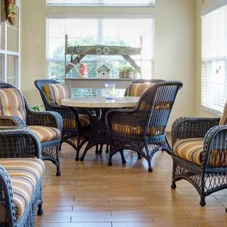 A cozy dining area with wicker furniture and plenty of natural light.