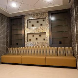 A modern lobby interior featuring a long upholstered sofa and decorative wall elements.