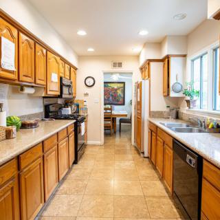 A spacious and well-lit kitchen with wooden cabinets and modern appliances.