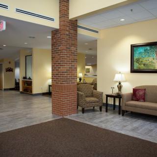 A cozy lobby area featuring a sofa, chairs, and decorative elements.